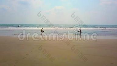 日落时分，两个中年人在海滩上<strong>打羽毛球</strong>。 爱，健康的生活和人际关系的概念